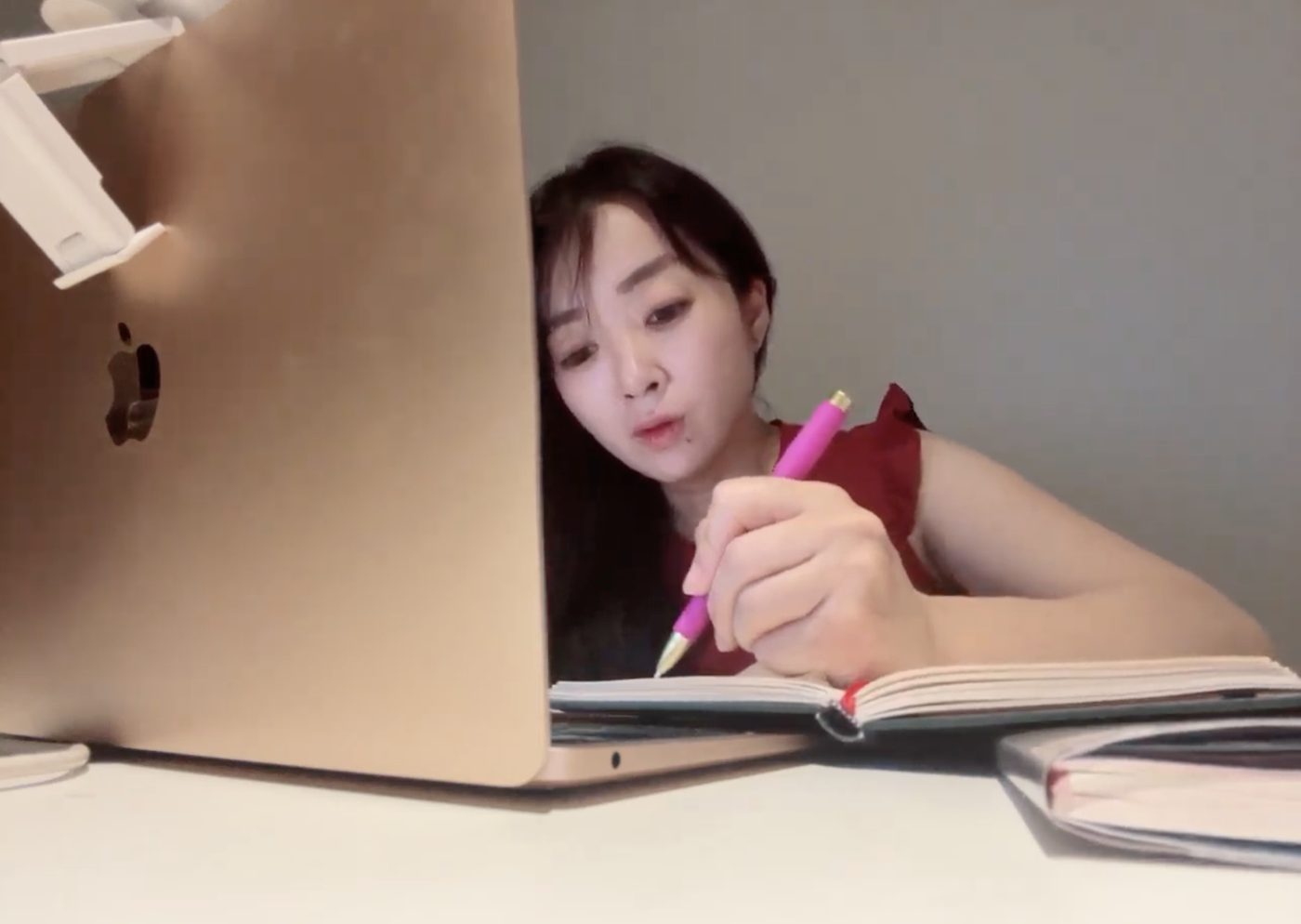ノートにメモを取りながらオンラインで話す田中美華